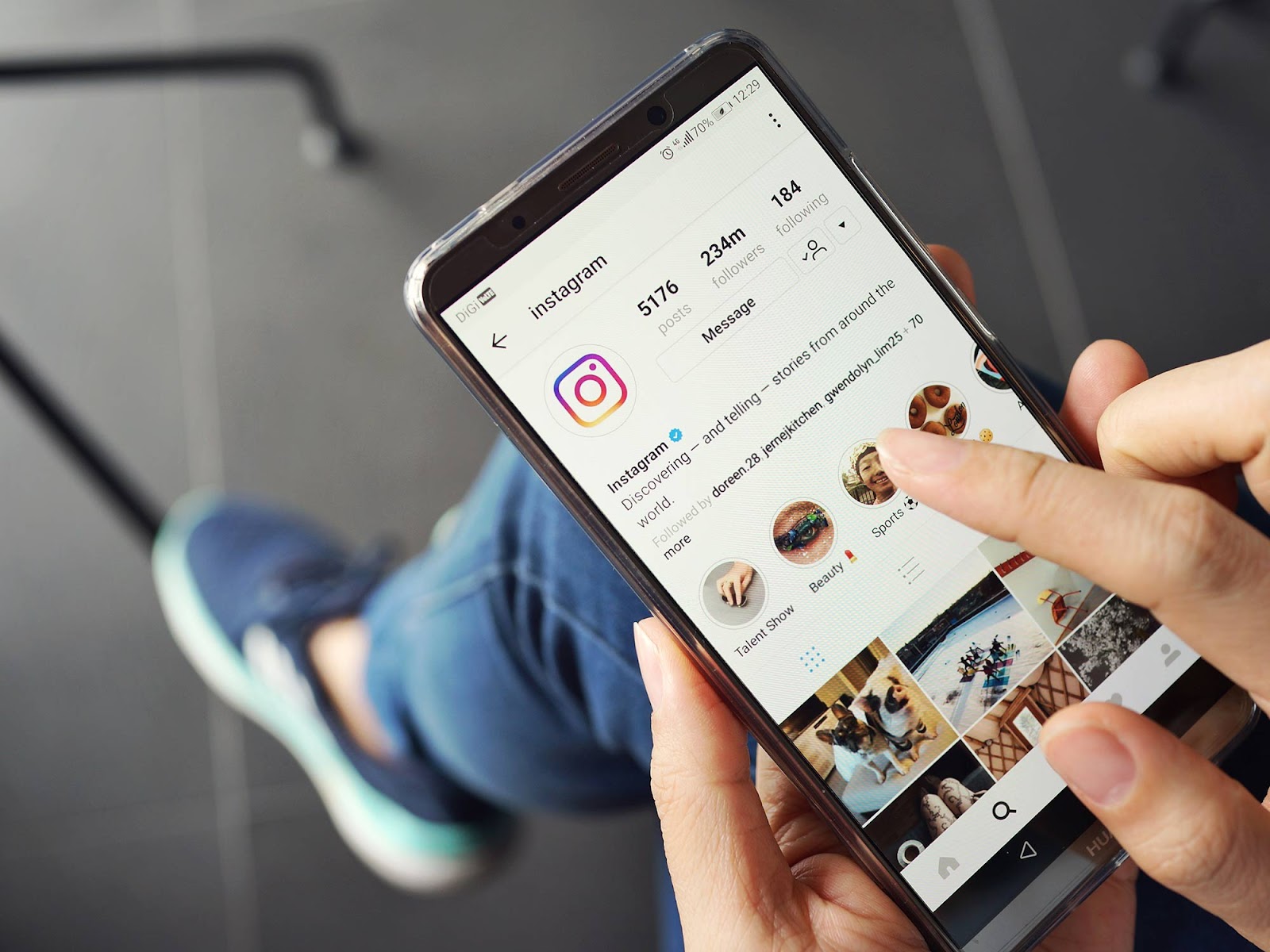 Comprar Seguidores: Como Funciona, Quais os Benefícios e os Perigos 5 Um close-up de uma pessoa usando um smartphone, navegando no feed do Instagram. A imagem simboliza a busca por um crescimento rápido e o ato de comprar seguidores para aumentar a visibilidade e o alcance.