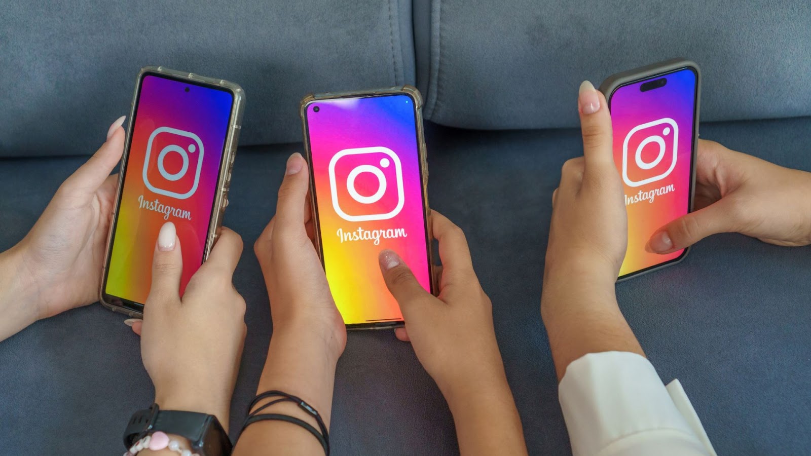 Por Que Baixar Stories do Instagram Pode Ser Fundamental? 9 Três smartphones são segurados por mãos diferentes, cada tela exibindo o logotipo colorido do Instagram. A imagem representa o uso generalizado do aplicativo, onde é possível visualizar e, com ferramentas específicas, baixar stories do Instagram.