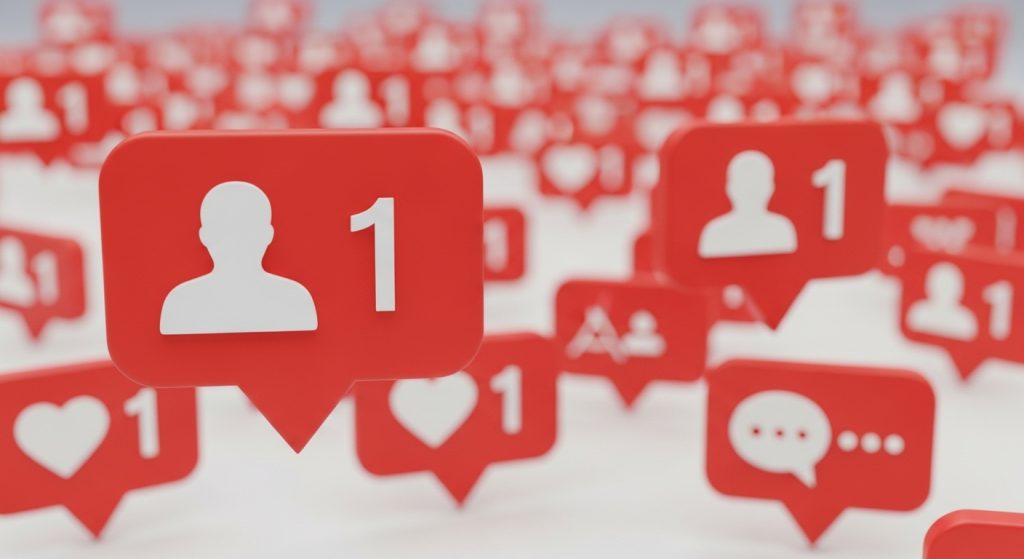 Uma renderização 3D com foco em diversas notificações vermelhas de redes sociais. A notificação em primeiro plano e com maior destaque mostra um ícone de silhueta humana branca e o número "1", representando um novo seguidor. Outras notificações desfocadas ao fundo incluem corações (likes) e balões de fala (comentários), também acompanhados do número "1". A imagem ilustra o conceito de crescimento rápido e aumento de engajamento, associado à ação de comprar seguidores e outras interações para um perfil online.