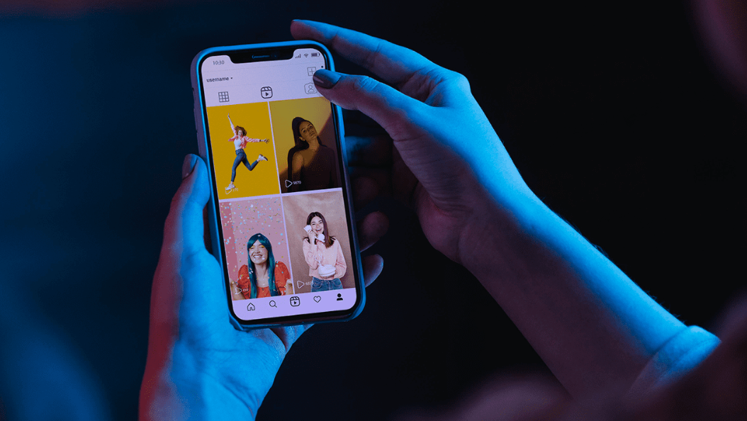 Pessoa segurando um celular com o perfil do Instagram aberto, ilustrando o gerenciamento de publicações e a possibilidade de apagar comentários indesejados.