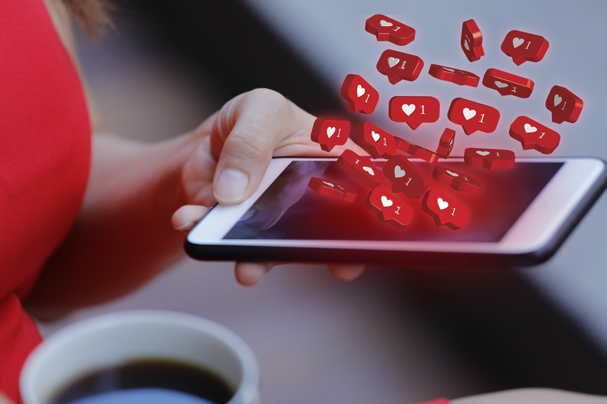 A imagem de um iphone gerando uma chuva de curtidas e interações visuais, imagem de logo do instagram aberta no iphone com laptop de fundo, mostrando estratégia de instagram para ganhar seguidores e clientes