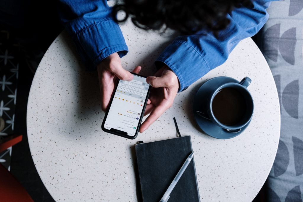 Como Desativar as Notificações do Instagram e Aproveitar o Modo Silencioso Instagram 7 A imagem de alguém engajado com seu smartphone, em um cenário que sugere trabalho ou relaxamento, destaca a importância da gestão do tempo e da experiência do usuário. Isso pode ser usado para indicar que o 'modo silencioso Instagram' é uma ferramenta para controlar as notificações e criar um ambiente mais tranquilo, propício à concentração ou ao lazer.