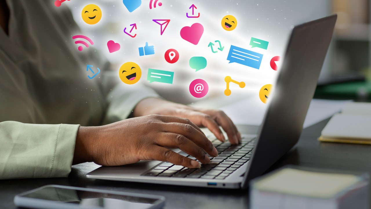 Duas Dicas Para Ganhar Muitos Seguidores no Instagram: Estratégias Simples e Eficazes 1 mulher em seu macbook escrevendo duas dicas para ganhar muitos seguidores no instagram com emojis flutuando