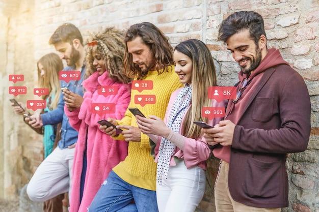 Pessoas reunidas, apoiadas em um muro utilizando seus smartphones para aprender a Como crescer no Instagram