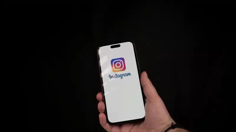 Imagem de uma mão segurando um smartphone com o logotipo do Instagram na tela, representando a importância da segurança do Instagram para proteger contas contra invasões e acessos não autorizados.