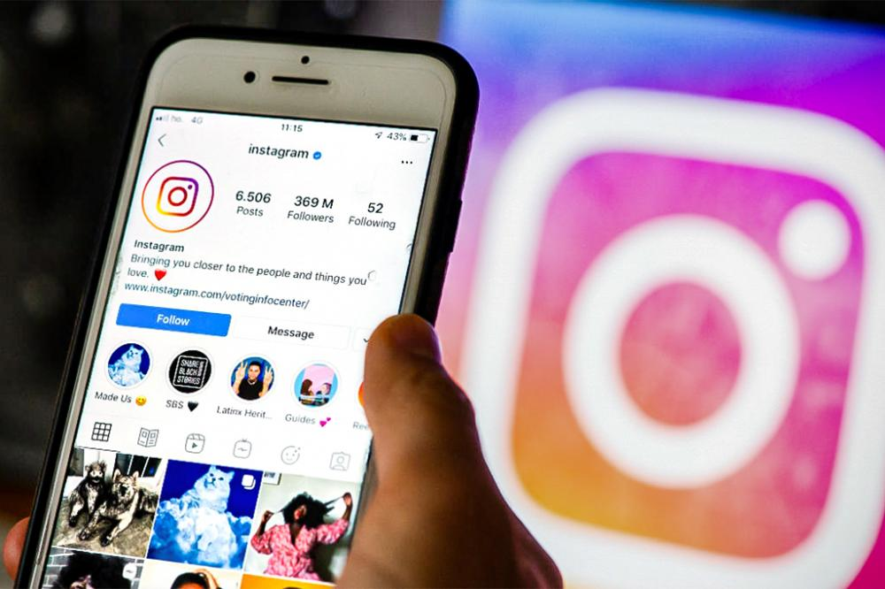 Foto de um smartphone exibindo um perfil oficial do Instagram, com milhões de seguidores. No fundo, o logotipo da rede social aparece em destaque. Essa imagem pode estar relacionada à ideia de Comprar Conta Instagram, mostrando a importância de perfis influentes com alto engajamento.