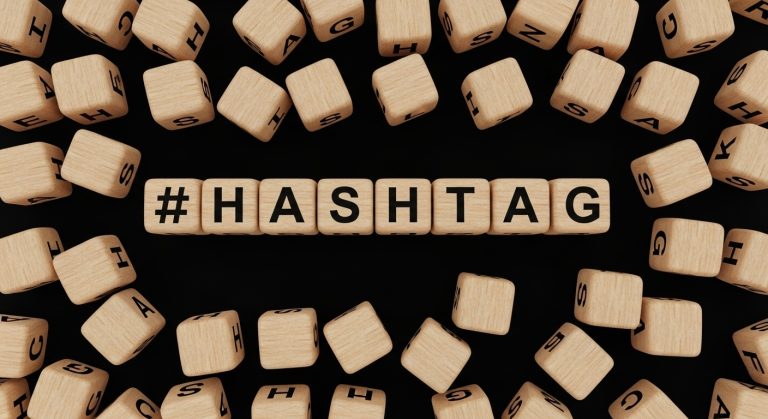 Blocos de Madeira espalhados formando a palavra hashtag, ensinando como ganhar seguidores no instagram