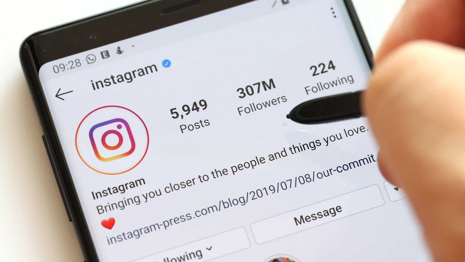 Quanto Custa Comprar Seguidores no Instagram em 2025? 1 Tela de um smartphone exibindo o perfil oficial do Instagram com milhões de seguidores. Uma pessoa aponta para a tela, simbolizando o desejo de crescer na plataforma. Estratégias para ganhar visibilidade incluem criar conteúdo de qualidade e até mesmo comprar seguidores para impulsionar o engajamento.