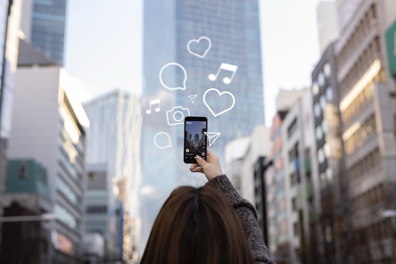 TOP 15 influenciadores de BH em 2025: Os Maiores Nomes do Cenário Digital de Minas 2 Influenciadora digital grava conteúdo para redes sociais com o smartphone, em meio a uma cidade moderna, simbolizando a produção de conteúdo urbano e o impacto dos influenciadores no ambiente digital.